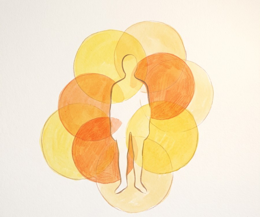 A figure standing among overlapping warm-toned circles, its outline fading where they meet